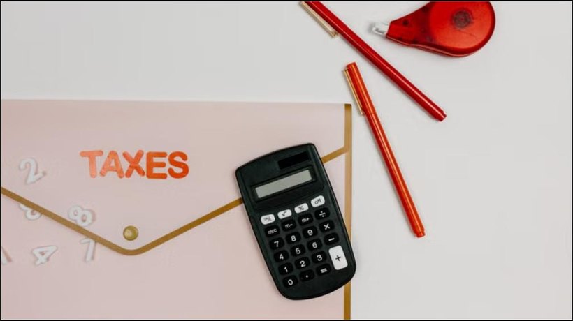 Calculator, pens, and a folder labeled Taxes